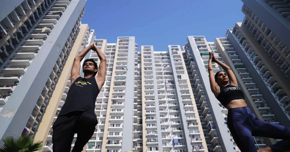 Panchsheel Greens II: yoga and open courtyard between residential towers
